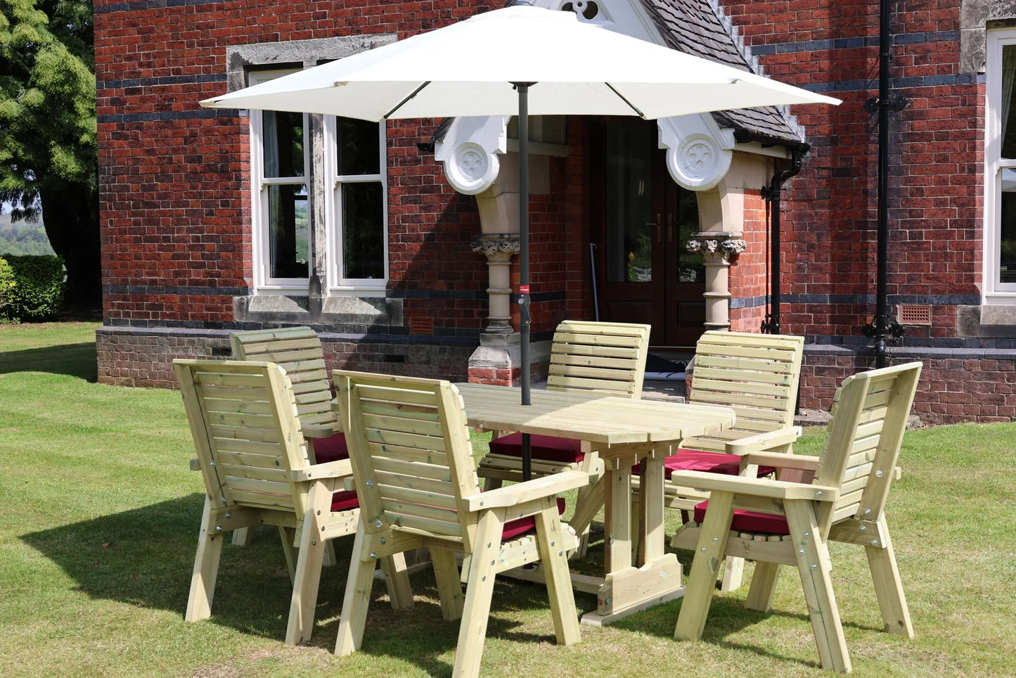 Heritage Tanalised 6 seat table set with cushions and parasol outside a country house